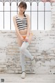 A woman in a striped top and white stockings posing for a picture.