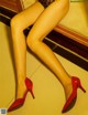 A woman in a black lingerie and red high heels.