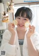 A woman holding two lemons in front of her face.