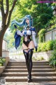 A woman with long blue hair standing on some steps.